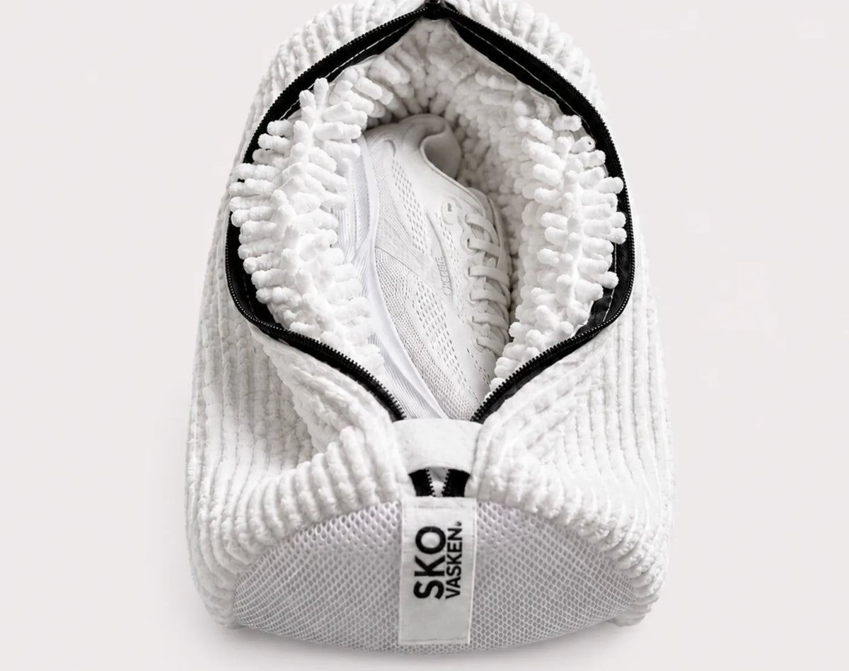 An open Skovasken wash bag showing its microfibre lining around a white trainer