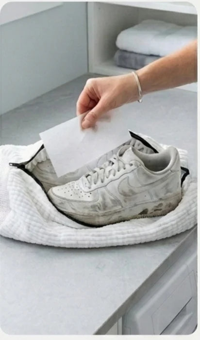 A dirty trainer inside an open Skovasken wash bag on a worktop