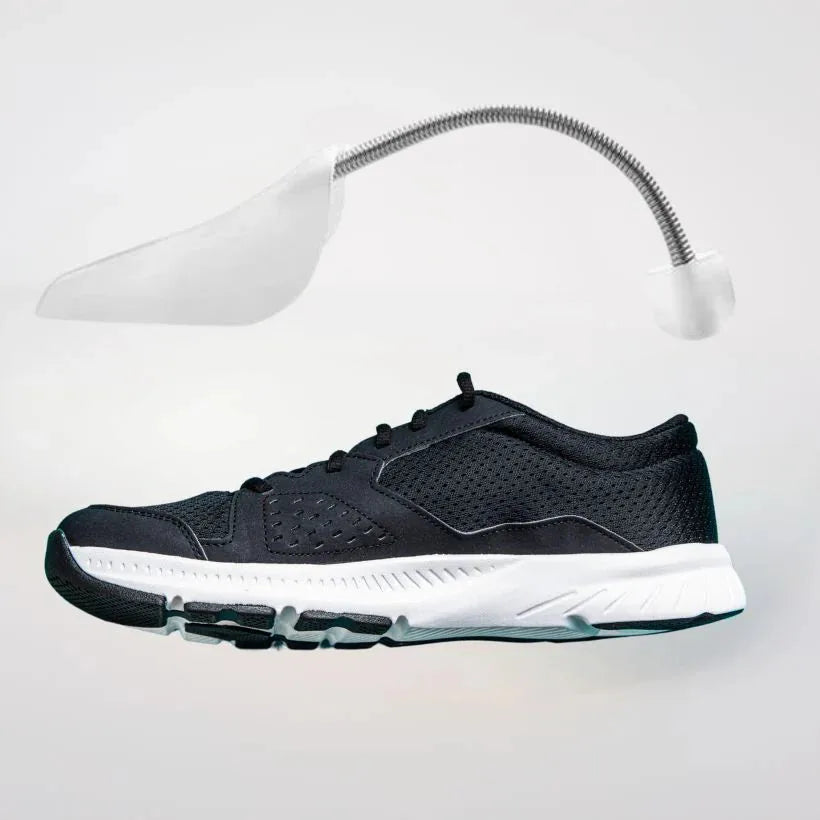 A sprung shoe shape preserver above a black trainer